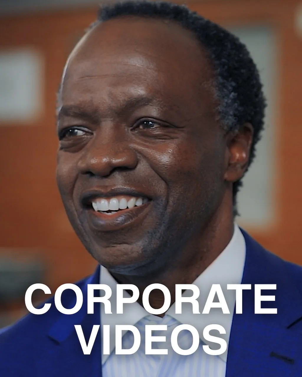 Close Up of smiling CEO in a blue suit looking off camera, a still from a corporate video produced by the Pretoria based production company The Chalk Factory.