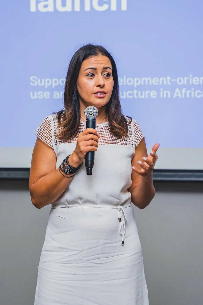 Corporate Event Photography Packages 2 A speaker captured at an event as she speaks to the audience through the microphone she is holding. Corporate event photography packages.