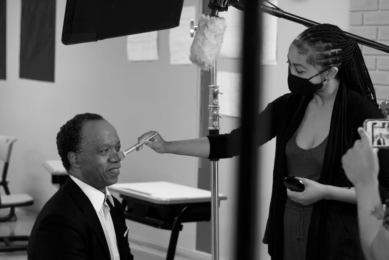 Behind the Scenes at The Chalk Factory A still of a make up artist working on a the face of a CEO on a project shot by The Chalk Factory Productions.